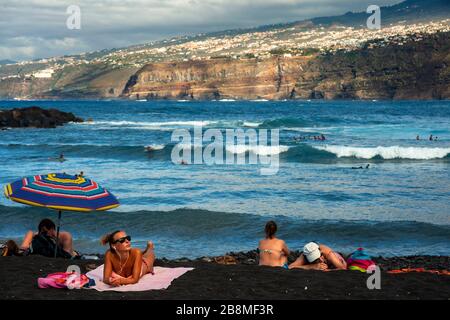 Touristen an den Klippen von los gigantes vulkanisch schwarzen Sandstränden in Puerto de la Cruz, auf der Insel Tenera, auf den Kanarischen Inseln, in Spanien Stockfoto