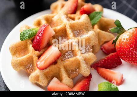 Belgische Waffeln mit Erdbeeren auf weißem Teller mit Nahansicht Stockfoto