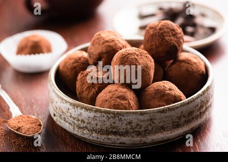 Hausgemachte dunkle Schokoladentrüffel auf Holzgrund. Nahaufnahme von Schokoladenbonbons Trüffel Stockfoto