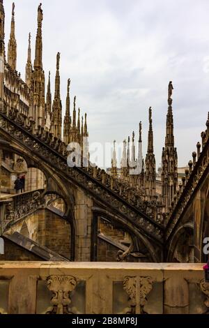 Blick auf das Dach des Duomo di Milano am regnerischen Frühlingstag. Es ist bekannt für den Wald der offenen Pinnacles und Turmspitzen, die auf heiklen fliegenden Strebepfeilern stehen. Stockfoto