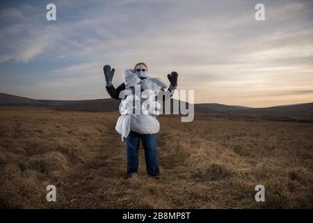 Perthshire Hills, Großbritannien. März 2020. Bild: Konzeptbild einer Person, die sich in der Mitte des Nirgendwo selbst isolieren wird und den begehrtesten Gegenstand in der Welt des toilettenpapiers trägt, während sie in hausgemachte persönliche Schutzausrüstung eingewickelt ist. Kredit: Colin Fisher/Alamy Live News Stockfoto