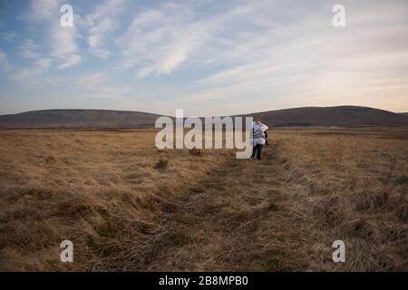 Perthshire Hills, Großbritannien. März 2020. Bild: Konzeptbild einer Person, die sich in der Mitte des Nirgendwo selbst isolieren wird und den begehrtesten Gegenstand in der Welt des toilettenpapiers trägt, während sie in hausgemachte persönliche Schutzausrüstung eingewickelt ist. Kredit: Colin Fisher/Alamy Live News Stockfoto