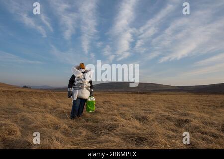 Perthshire Hills, Großbritannien. März 2020. Bild: Konzeptbild einer Person, die sich in der Mitte des Nirgendwo selbst isolieren wird und den begehrtesten Gegenstand in der Welt des toilettenpapiers trägt, während sie in hausgemachte persönliche Schutzausrüstung eingewickelt ist. Kredit: Colin Fisher/Alamy Live News Stockfoto