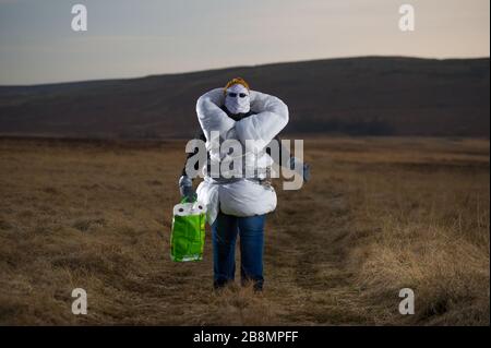 Perthshire Hills, Großbritannien. März 2020. Bild: Konzeptbild einer Person, die sich in der Mitte des Nirgendwo selbst isolieren wird und den begehrtesten Gegenstand in der Welt des toilettenpapiers trägt, während sie in hausgemachte persönliche Schutzausrüstung eingewickelt ist. Kredit: Colin Fisher/Alamy Live News Stockfoto