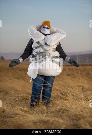 Perthshire Hills, Großbritannien. März 2020. Bild: Konzeptbild einer Person, die sich in der Mitte des Nirgendwo selbst isolieren wird und den begehrtesten Gegenstand in der Welt des toilettenpapiers trägt, während sie in hausgemachte persönliche Schutzausrüstung eingewickelt ist. Kredit: Colin Fisher/Alamy Live News Stockfoto