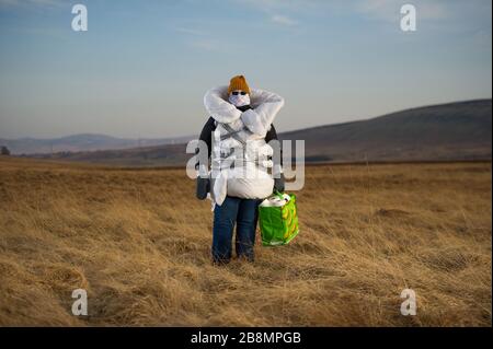 Perthshire Hills, Großbritannien. März 2020. Bild: Konzeptbild einer Person, die sich in der Mitte des Nirgendwo selbst isolieren wird und den begehrtesten Gegenstand in der Welt des toilettenpapiers trägt, während sie in hausgemachte persönliche Schutzausrüstung eingewickelt ist. Kredit: Colin Fisher/Alamy Live News Stockfoto