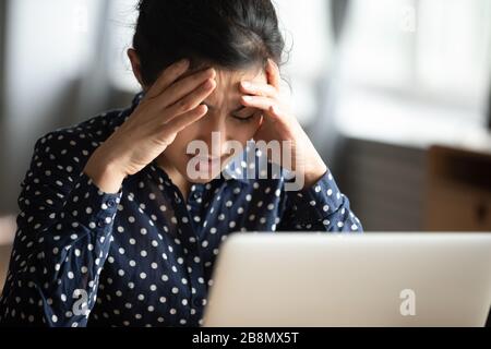 Unglückliche Indianerin berührt Tempel und fühlt sich unwohl Stockfoto