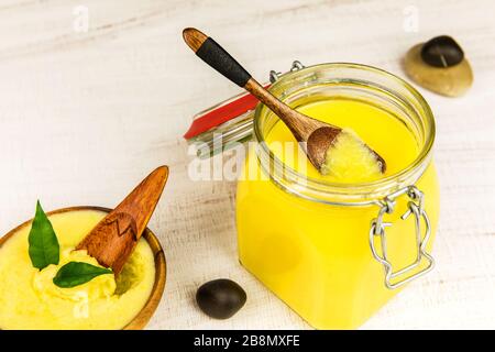 Ghee oder geklärte Butter im Mixbecher. Gesunde Ernährung und Verwendung von frisch zubereiteten Produkten aus biologischem Anbau. Gesunde Zutat zum Kochen organischer Speisen. Löffel mit Ghee aber Stockfoto