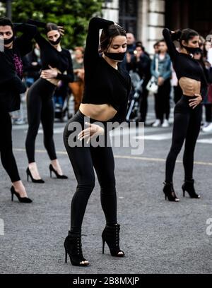 Tanz-Truppe in schwarz gekleidet mit Gesichtsmasken über dem Mund, internationaler Frauentag 2020, Valencia, Spanien. Stockfoto