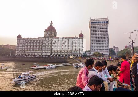 MUMBAI, INDIEN - DEC. 8, 2019 : Besucher, die einen Abend in der Nähe des Taj Mahal Palace Hotel genießen. Es ist ein historisches, 5-Sterne-Hotel in Maharashtra. Stockfoto