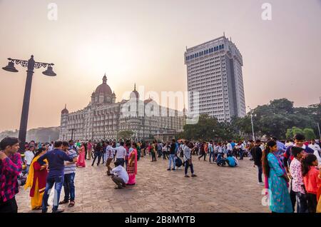 MUMBAI, INDIEN - DEC. 8, 2019 : Besucher, die einen Abend in der Nähe des Taj Mahal Palace Hotel genießen. Es ist ein historisches, 5-Sterne-Hotel in Maharashtra. Stockfoto