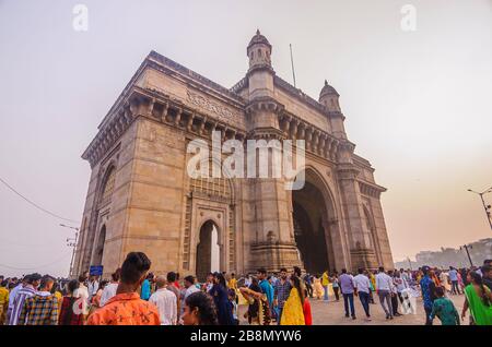 MUMBAI, INDIEN - DEC. 8, 2019: Besucher, die in der Nähe von Gateway of India, gegenüber der wichtigsten Touristenattraktion Taj Mahal Palace und Tower Hotel genießen. Stockfoto