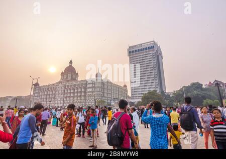 MUMBAI, INDIEN - DEC. 8, 2019 : Besucher, die einen Abend in der Nähe des Taj Mahal Palace Hotel genießen. Es ist ein historisches, 5-Sterne-Hotel in Maharashtra. Stockfoto