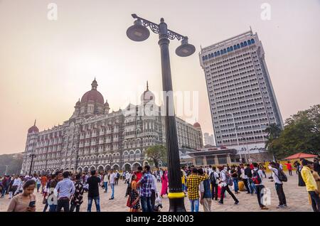 MUMBAI, INDIEN - DEC. 8, 2019 : Besucher, die einen Abend in der Nähe des Taj Mahal Palace Hotel genießen. Es ist ein historisches, 5-Sterne-Hotel in Maharashtra. Stockfoto