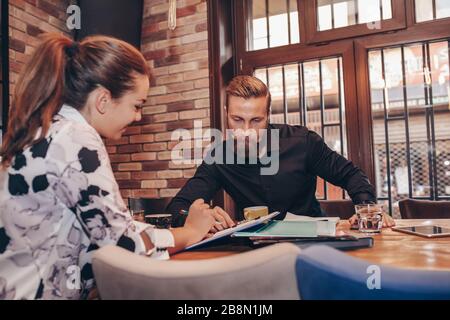 Junge Geschäftsleute zusammen Arbeiten auf Papier arbeiten und sprechen über Berichte und Finanz im Cafe. Stockfoto