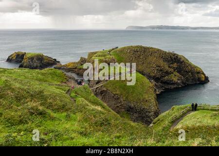 Die winzige Insel Carrickarede ist durch die Carrick-a-Rede Seil Bridge, die vom National Trust unterhalten wird, mit dem Festland verbunden. Stockfoto