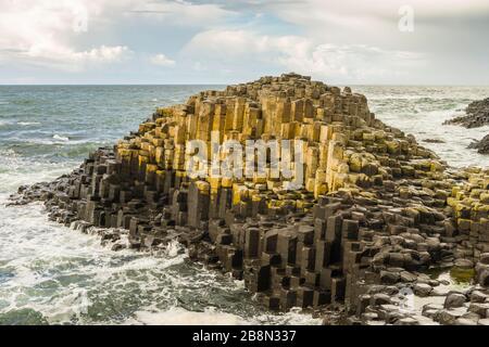 Der Giant's Causeway ist ein Bereich von ineinander greifenden sechseckigen Vulkanbasaltsäulen an der Nordküste des County Antrim, Nordirland, Großbritannien. Stockfoto