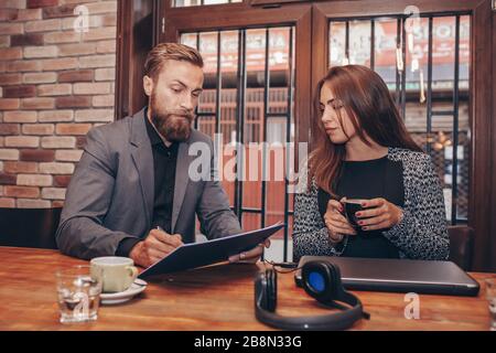 Junge Geschäftsleute zusammen Arbeiten auf Papier arbeiten und sprechen über Berichte und Finanz im Cafe. Stockfoto