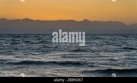 Sonnenaufgang über den Bergen von Saudia Arabien vom Bayview Taba Heights Resort entlang des Roten Meeres, Ägypten, Naher Osten. Stockfoto