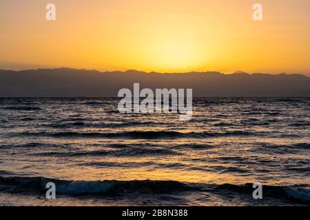 Sonnenaufgang über den Bergen von Saudia Arabien vom Bayview Taba Heights Resort entlang des Roten Meeres, Ägypten, Naher Osten. Stockfoto