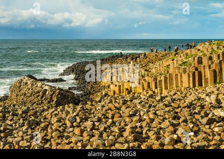 Der Giant's Causeway ist ein Bereich von ineinander greifenden sechseckigen Vulkanbasaltsäulen an der Nordküste des County Antrim, Nordirland, Großbritannien. Stockfoto