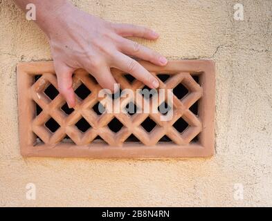 Halten Sie die Rippen in der Luft fest. Perforierter Backstein mit Löchern in der Wand. Stockfoto