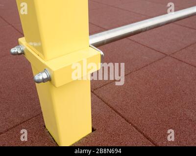 Rahmen für schwedische Metallleiter mit gelben Balken auf ablautem dunklem Hintergrund. Moderne Sportgeräte, Gymnastik, Bodybuilding Training sind Stockfoto