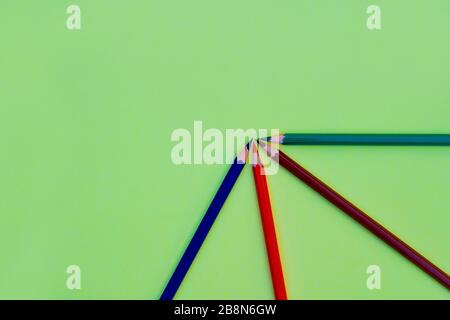 Verschiedenfarbige Bleistiftkrebse, die in einem Viertelkreis auf einem hellgrünen Papierhintergrund angeordnet sind Stockfoto
