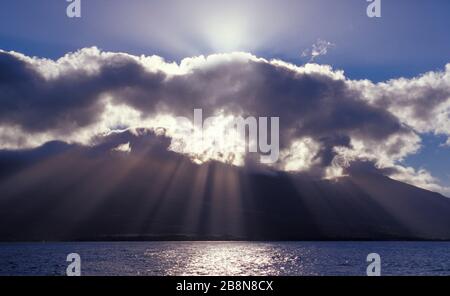 Sonnenstrahlen platzen hinter einer Wolke über die West Maui Mountains, Maui, Hawaii. Stockfoto