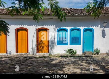 Fassade eines typischen bunten Hauses mit gepflasterter Straße in Paraty, Rio de Janeiro, Brasilien. Das erhaltene koloniale Zentrum der Stadt wurde auf UNE einbezogen Stockfoto