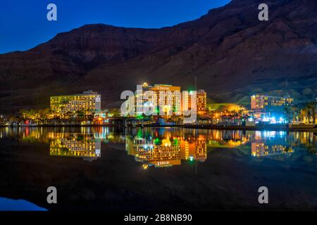 Hotels, die sich nachts im Toten Meer in Ein Bokek, Israel, Naher Osten widerspiegeln. Stockfoto