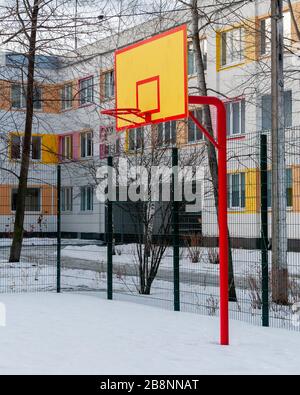 Schneebedeckter Basketballplatz im Schulhof Stockfoto