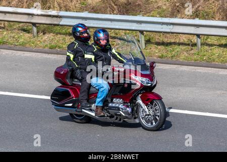 Red Honda Goldwing Motorradfahrer; Fahrzeugverkehr, Zweiradtransport, moderne Fahrzeuge, Motorräder, Fahrzeug, Straßen, Motorräder, Motorradfahrer, Motorradfahrer, die auf der Autobahn M6 in Chorley, Großbritannien fahren Stockfoto