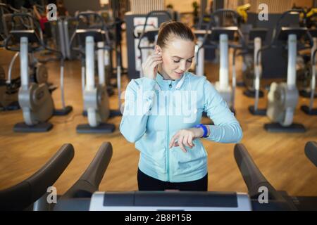 Hochwinkelige Portraits sportlicher junger Frauen, die auf dem Laufband in einem modernen Fitnessstudio trainieren, kopiere Platz Stockfoto