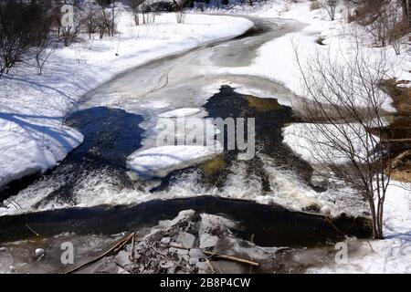 Die Frühlingsschmelze an einem Biber dämpfte den kleinen Fluss/Bach im Gatineau Park, Quebec, Kanada. Stockfoto