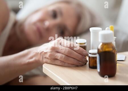 Falten weiblichen Hand, die Glasflasche mit Pillen nimmt. Stockfoto