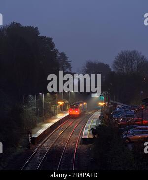 Transport für Wales Klasse 142 Schrittmacherzug 142077, der in der Dämmerung im feuchten Nebel den Bahnhof Llanishen in den Cardiff-Tälern anruft Stockfoto