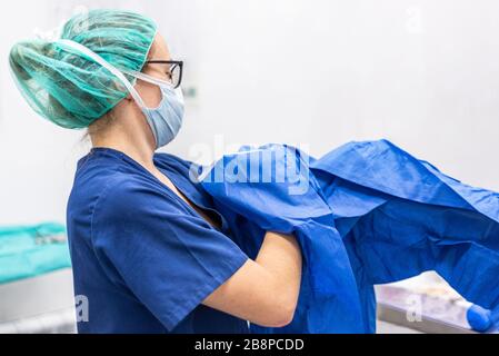 Covid-19. Krankenschwester legt Schutztücher auf. Persönliche Schutzausrüstung im Kampf gegen die Coronavirus Krankheit . Stockfoto