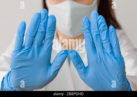 Stoppen Sie SARS-COV, SARSCoV, Virus 2020, MERS-COV, chinese Virus COVID-19. Close-Womans Hände in blauen medizinischen Handschuhen zeigen EIN STOPPZEICHEN für Krankheit. Arzt Stockfoto