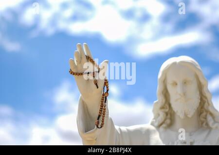 Statue von Jesus, die einen Rosary hält Stockfoto