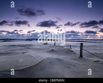 Sonnenaufgang auf den sich bewegenden Dünen am windigen Morgen. Debki, Ostsee, Polen. Stockfoto