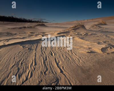 Sich bewegende Dünen in der Nähe von Debki, am Ufer der Ostsee. Querformat direkt nach Sonnenaufgang. Sichtbare Flairs. Stockfoto