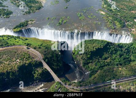 Luftaufnahme der Victoriafälle zwischen Simbabwe und Sambia in Afrika. Sieben Naturwunder der Welt. Fluss Sambezi und Grenzbrücke.