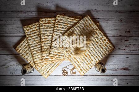 Passahmatzos, zwei Kerzenhalter, getrocknete Blumen und David Halskette auf Holzhintergrund Stockfoto