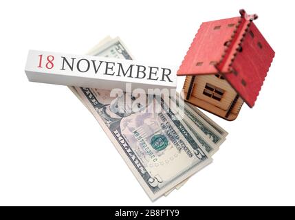 Geld und rotes Zuhause mit Kalender. Das Konzept der finanziellen Unabhängigkeit und der geplante Starttermin für den 18. November Stockfoto