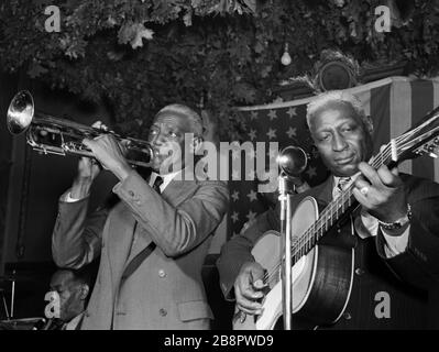 NEW YORK, NEW YORK - JUNI 1946: (L-R) US-amerikanischer Jazzklarinettist George Lewis (1900-1968), US-amerikanischer Jazztrompeter Bunk Johnson (1879-1949), US-amerikanischer Jazzgitarrist und Kontrabassist Alcide Pavageau (1888-1969) und US-amerikanischer Folk- und Bluessänger, Musiker und Songwriter Lead Belly (1888-1949) auf der Bühne Juni, 1946 im Stuyvesant Casino in New York. Kredit: William Gottliebe / Rock negative / MediaPunch Stockfoto