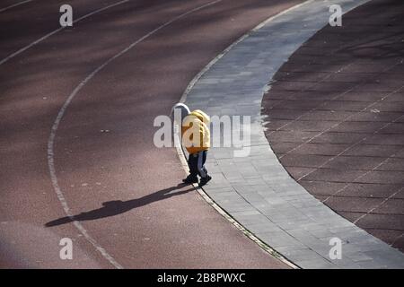 Kleiner Junge auf einer kreisförmigen Sportstrecke Stockfoto