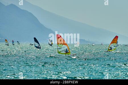 Riva del Garda, Lago di Garda, Italien - 12. Juni 2018: Windsurfer surfen auf Wellen im Gardasee, Fahrer surfen mit hoher Geschwindigkeit am Gardasee, R. Stockfoto