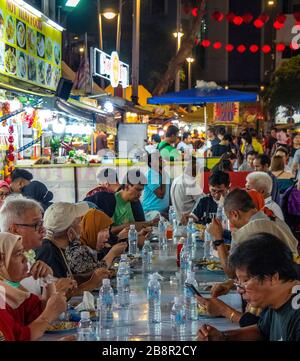 Eine Gruppe von Personen, die im Freien im Jalan Alor Bukit Bintang Kuala Lumpur Malaysia essen. Stockfoto