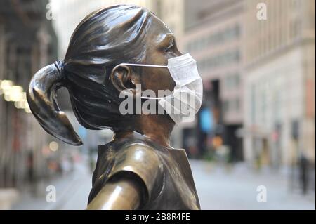 New York, Vereinigte Staaten. März 2020. Die "Fearless Girl"-Statue steht gegenüber der New Yorker Börse (NYSE) und trägt eine Coronavirus-Maske. (Foto von Luiz Roberto Lima-ANB/Pacific Press) Credit: Pacific Press Agency/Alamy Live News Stockfoto